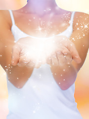 Image showing magic twinkles on female hands