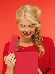 Image showing lovely woman in red dress with opened gift box