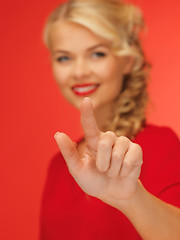 Image showing woman in red dress pressing virtual button