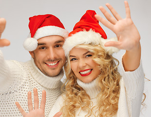 Image showing family couple in sweaters and santa's hats