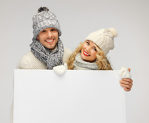 Image showing couple in a winter clothes holding blank board