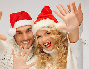 Image showing family couple in sweaters and santa's hats