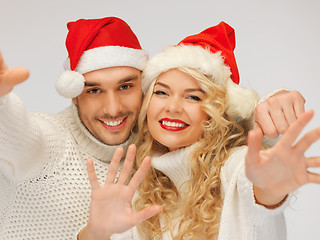 Image showing family couple in sweaters and santa's hats