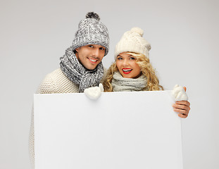 Image showing couple in a winter clothes holding blank board