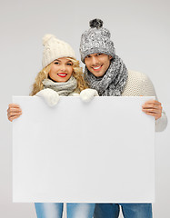 Image showing couple in a winter clothes holding blank board