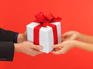 Image showing man and woman's hands with gift box