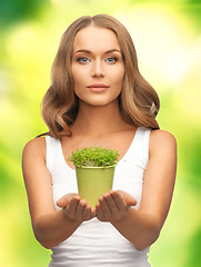 Image showing woman with green grass in pot