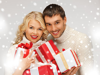 Image showing romantic couple in a sweaters with gift boxes