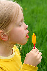 Image showing Licking yellow ice-cream