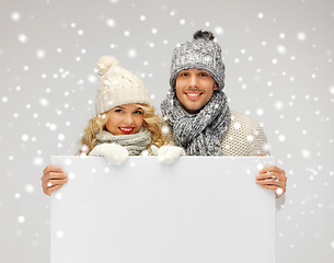 Image showing couple in a winter clothes holding blank board