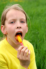 Image showing Licking yellow ice-cream