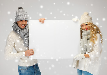 Image showing couple in a winter clothes holding blank board