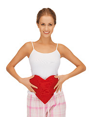 Image showing happy and smiling woman with heart-shaped pillow