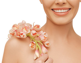 Image showing woman's shoulder and hands holding orchid flower