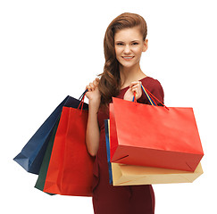 Image showing teenage girl in red dress with shopping bags