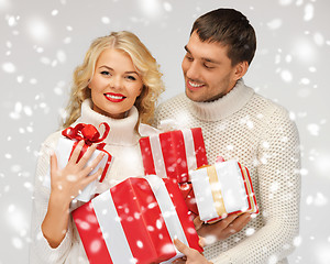 Image showing romantic couple in a sweaters with gift boxes