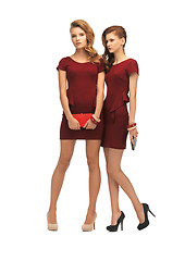 Image showing two teenage girls in red dresses with clutches