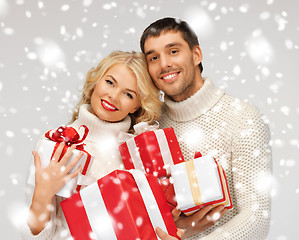 Image showing romantic couple in a sweaters with gift boxes