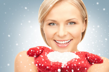 Image showing beautiful woman in red mittens with snow