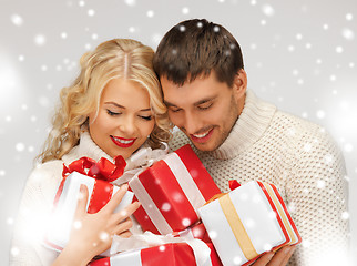 Image showing romantic couple in a sweaters with gift boxes