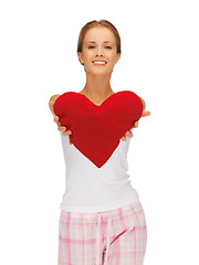 Image showing happy and smiling woman with heart-shaped pillow