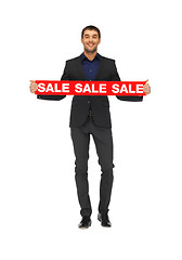 Image showing handsome man in suit with sale sign