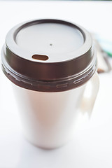 Image showing Coffee in paper cup with sugar packs on white background