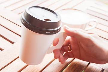 Image showing Hot coffee in paper cup serving at coffee shop