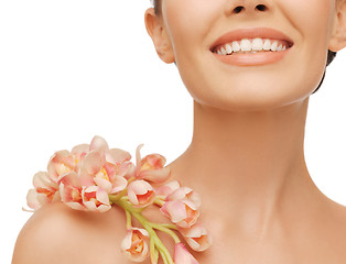 Image showing smiling woman with orchid flower on her shoulder