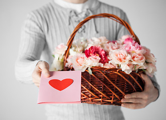 Image showing man holding basket full of flowers and postcard