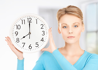 Image showing businesswoman with wall clock