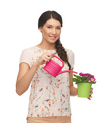 Image showing housewife with flower in pot and watering can