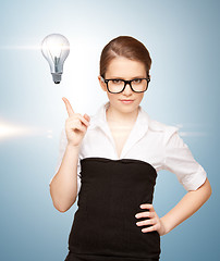 Image showing woman pointing her finger at light bulb