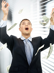 Image showing businessman in money rain indoors