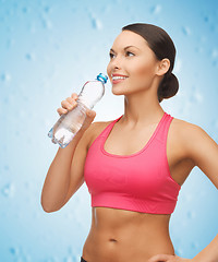 Image showing sporty woman drinking water from bottle