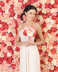 Image showing woman with bouquet and background full of roses