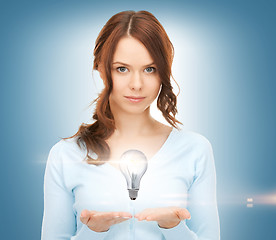 Image showing woman showing light bulb on the palm of her hands