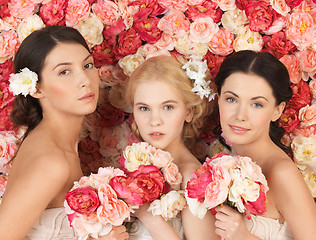 Image showing three women with background full of roses