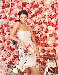 Image showing woman with bicycle and background full of roses