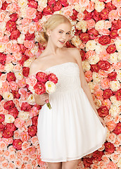 Image showing woman with bouquet and background full of roses