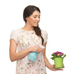 Image showing woman holding pot with flower and spray bottle