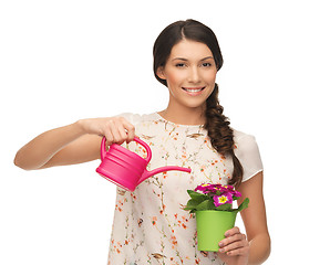 Image showing housewife with flower in pot and watering can