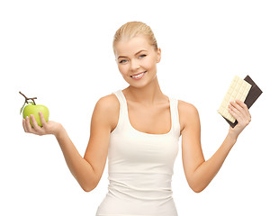 Image showing sporty woman with apple and chocolate bars