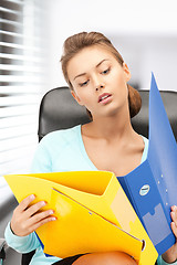 Image showing young businesswoman with folders sitting in chair