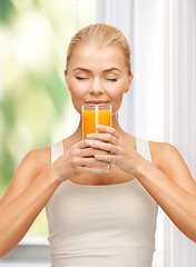 Image showing young woman drinking orange juice