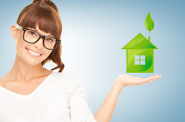 Image showing woman holding green house in her hands