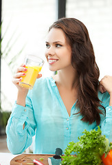 Image showing young woman holding glass of orange juice