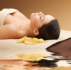 Image showing woman in spa salon lying on the massage desk