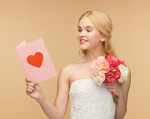 Image showing young woman holding flower and postcard