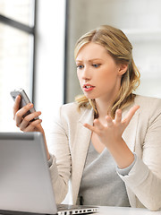 Image showing confused woman with cell phone